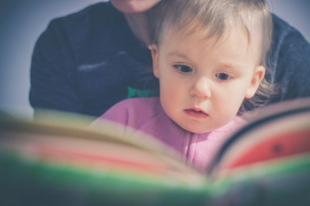 LA child and a parent reading a book together